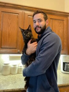 A man holding a cat in his arms.