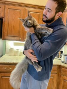 A man holding a cat in his arms.