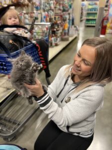 A woman holding a cat in her hands.