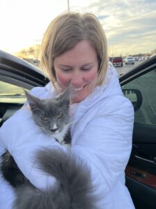 A woman holding onto a cat in her arms.