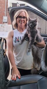 A woman holding a cat in her arms.