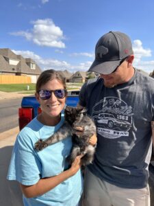 A man and woman holding a cat in their arms.