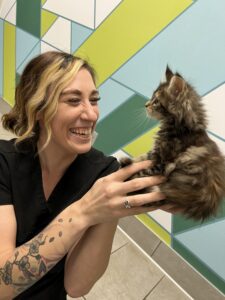 A woman holding a cat in her hands.