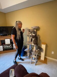 A woman standing in front of some cat trees.