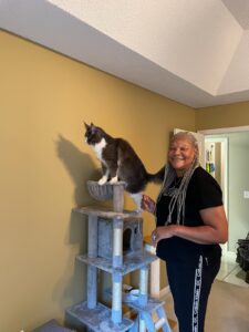 A woman standing next to a cat on top of a tower.