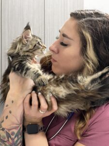 A woman holding a cat in her arms.