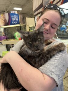 A woman holding a cat in her arms.