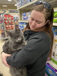 A woman holding a cat in her arms.