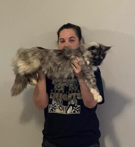 A woman holding a cat in her arms.