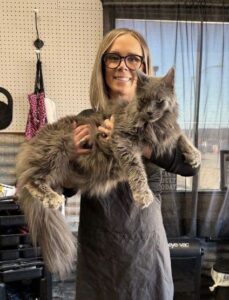 A woman holding a large cat in her arms.