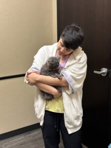 A woman holding a cat in her arms.