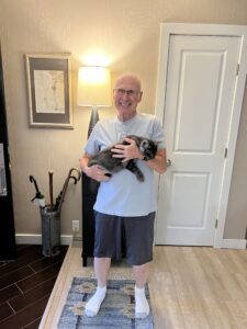 A man holding a dog in his arms.